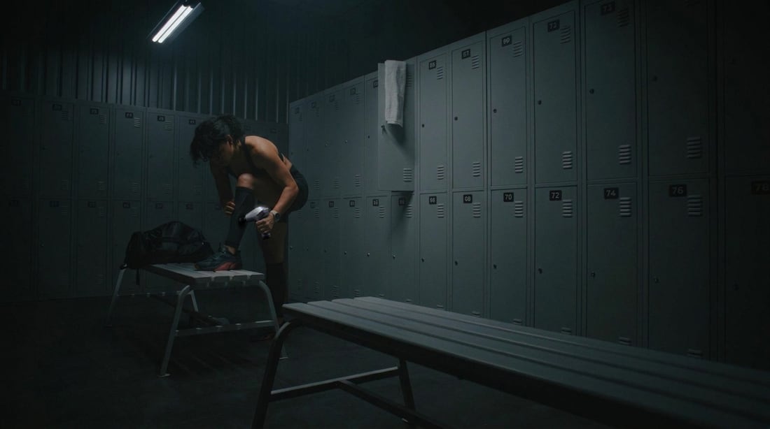 Athlete using the EVURON ARC Pro on the calf in a locker room after training.